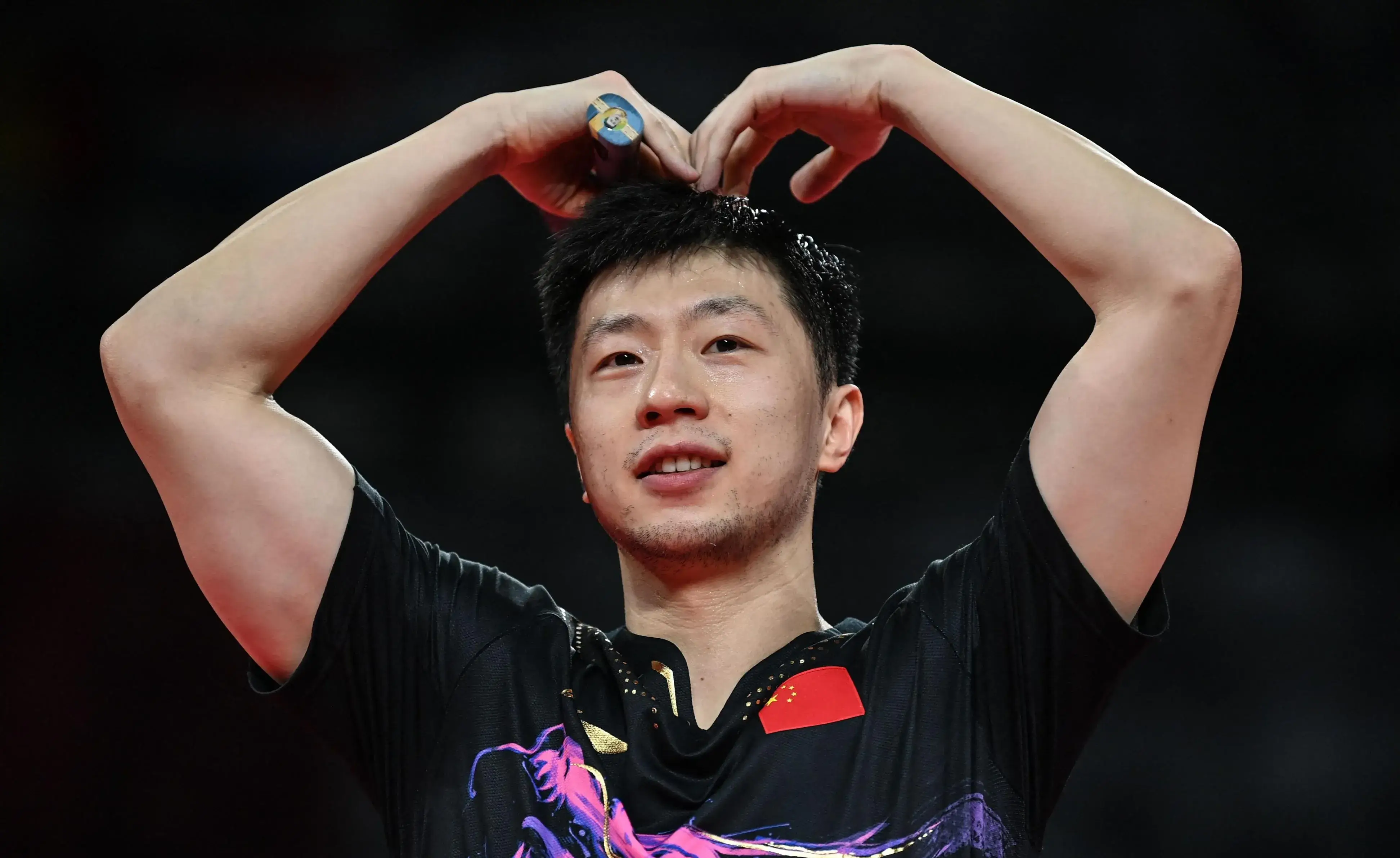 Ma Long raising both hands making a heart gesture to the crowd after winning the Rio 2016 Olympic men's singles title