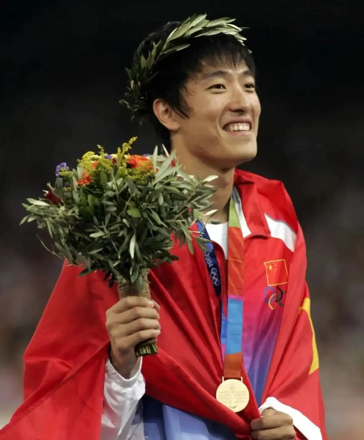 Liu Xiang on the podium with the Chinese flag at the Athens 2004 Olympics, Olympic 110m hurdles champion
