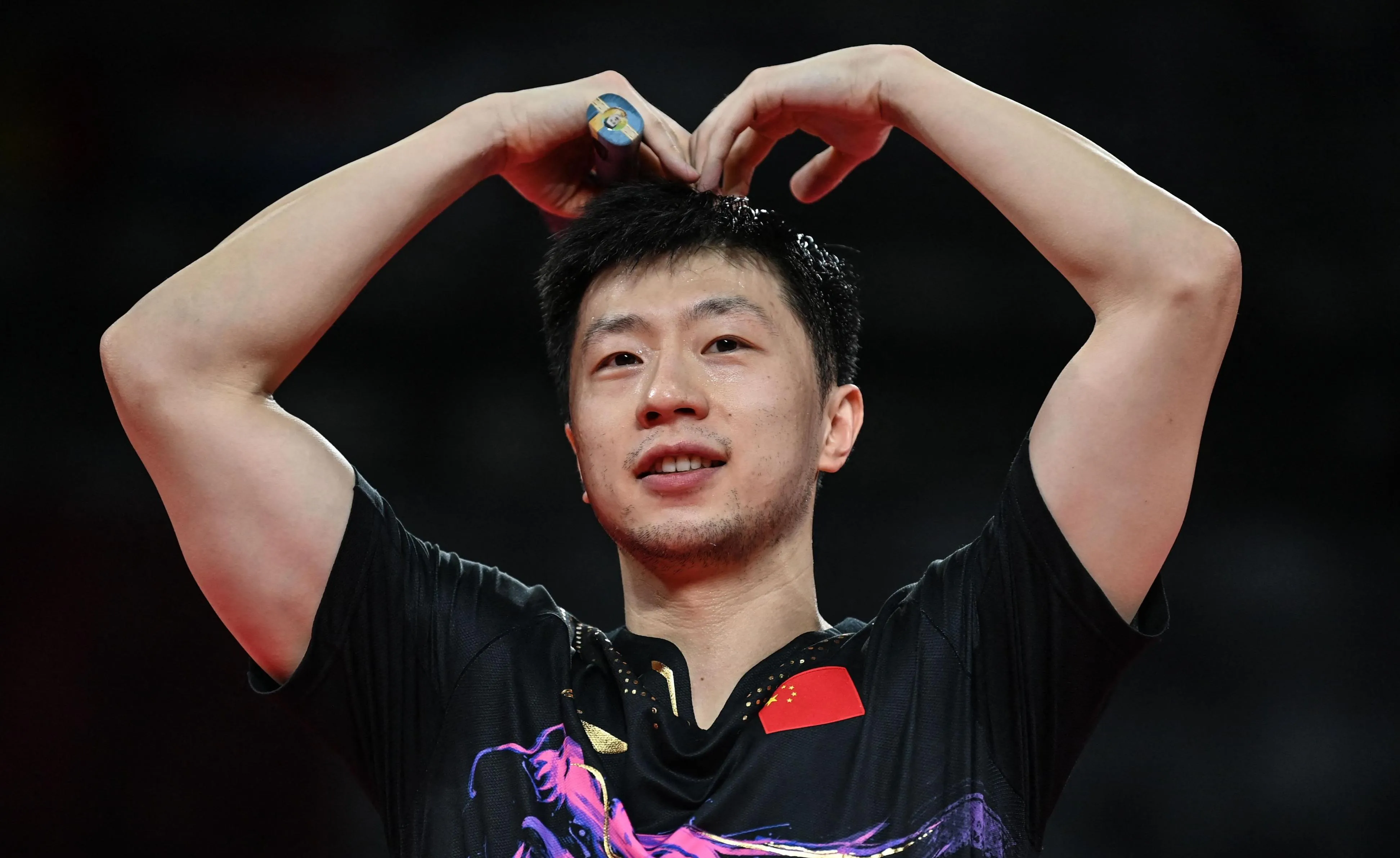 Ma Long raising both hands making a heart gesture to the crowd after winning the Rio 2016 Olympic men's singles title