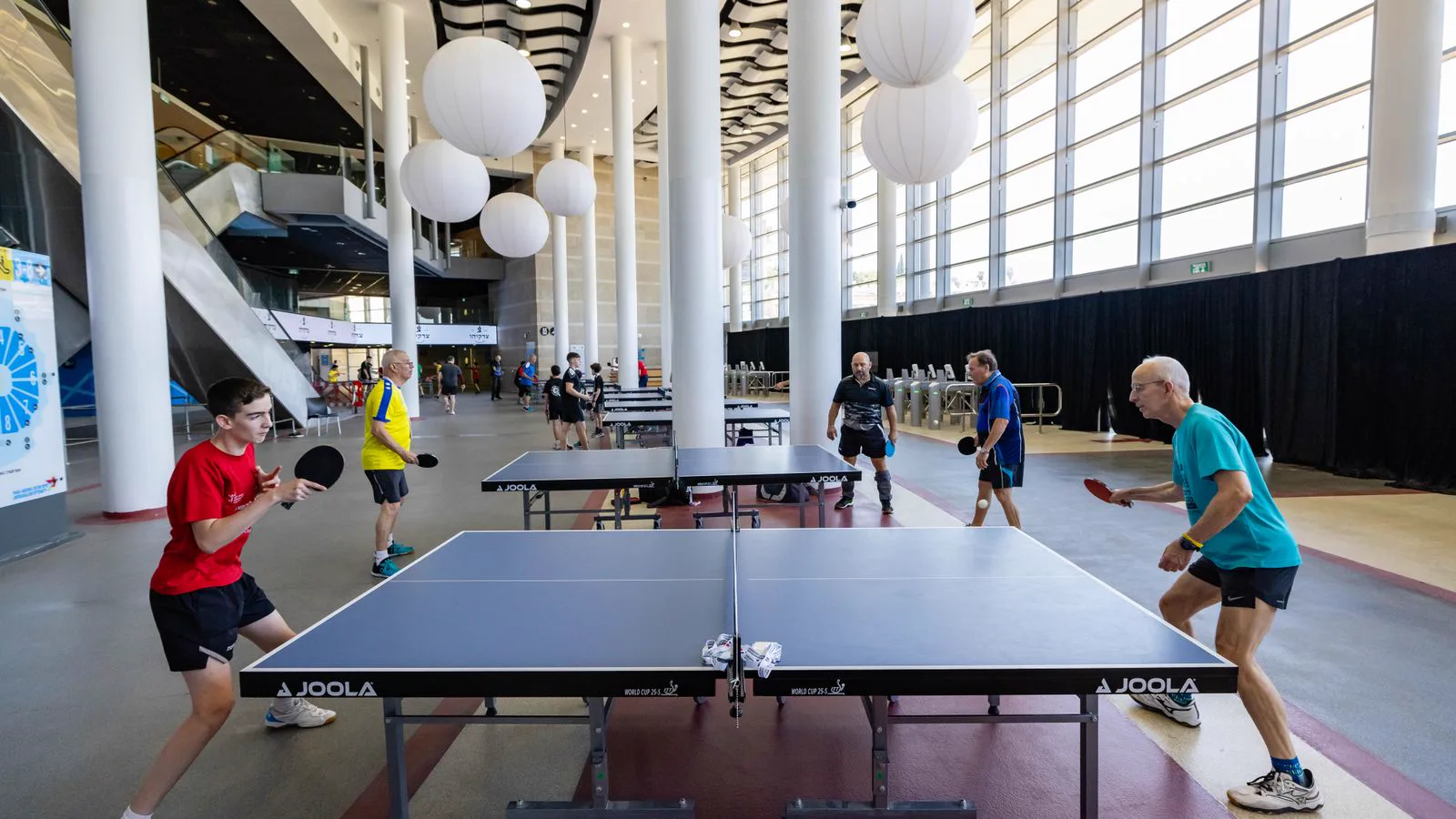 A table tennis match in a modern indoor venue — illustrative stock, not a portrait of Deng Yaping (historical editorial photographs are copyright-constrained)