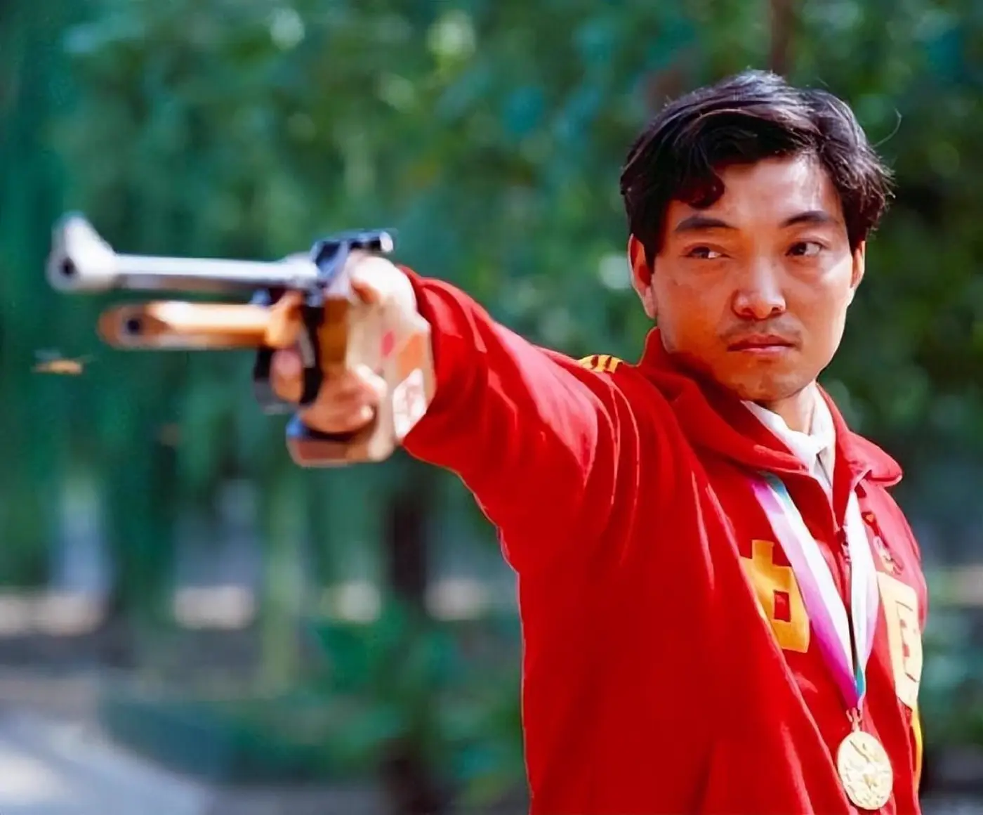 Xu Haifeng holding a pistol during his shooting years